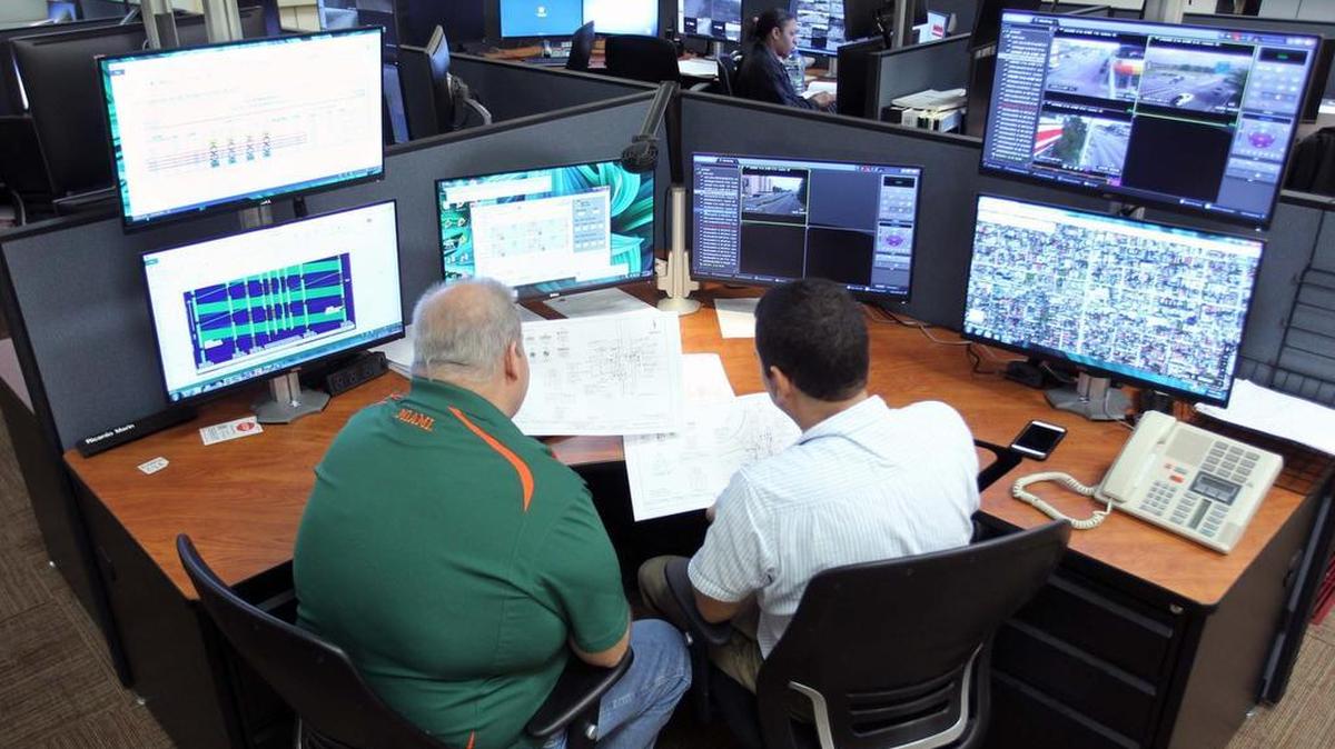 Los ingenieros Juan Peña (izq.) y Ricardo Marín trabajan en el centro de comando y control de semáforos del Condado Miami-Dade.
