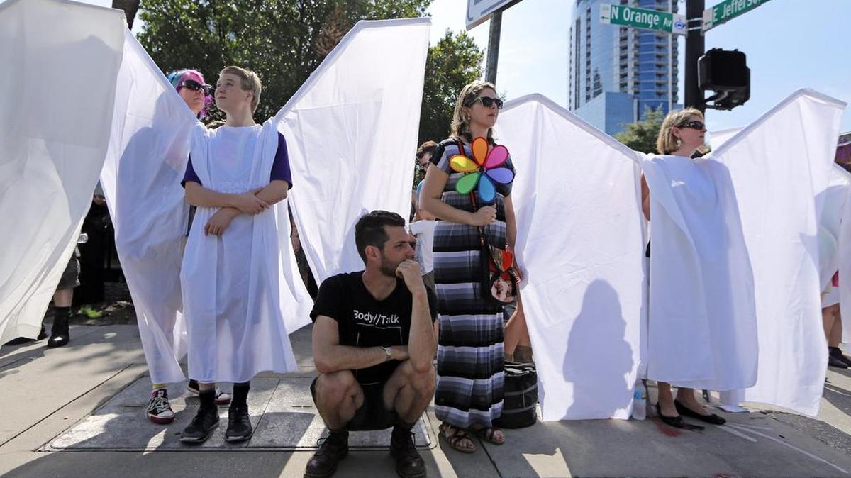 Voluntarios con las alas del ángel muestran su apoyo para contrarrestar cualquier grupo que se presentara durante el funeral en la Catedral Iglesia de San Lucas de una de las víctimas del club Pulse el sábado 18 de junio de 2016.