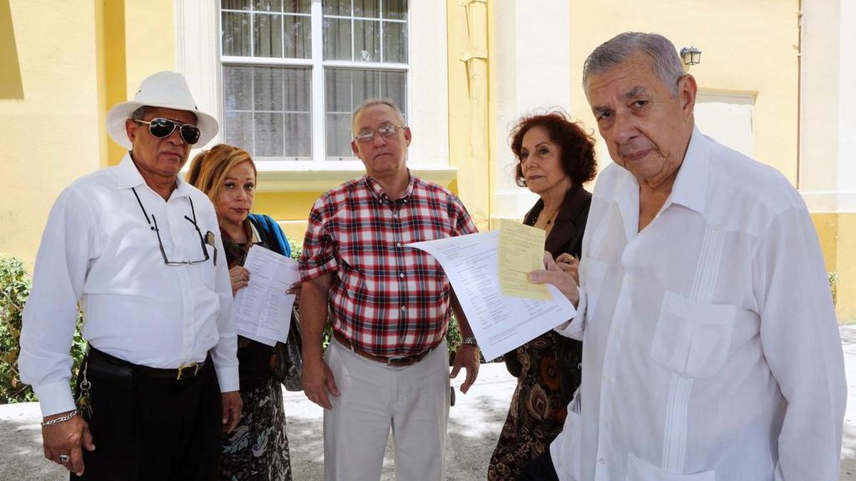 Salvador Romaní (der.) muestra la denuncia realizada a la Policía de Miami el viernes, por el supuesto allanamiento a las oficinas del Colegio Nacional de Periodistas en el Exilio, por otro grupo de periodistas.