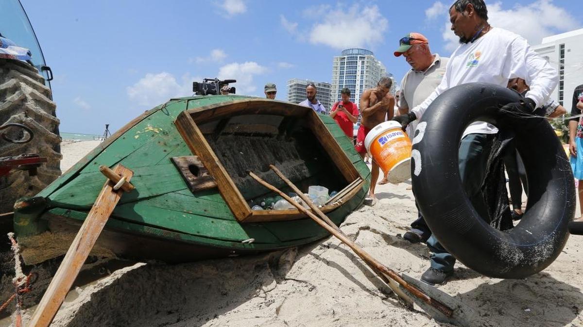 Empleados del Departamento de Recreación y Parques del condado de Miami-Dade, se preparan para retirar un bote usado por cubanos para llegar a la costa de Miami Beach a inicios de julio.