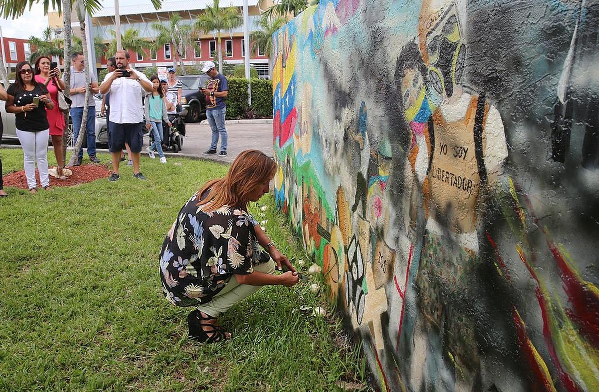 Maria Eugenia Tavares coloca flores en el mural homenaje a los caídos en las protestas antigubernamentales en Venezuela.