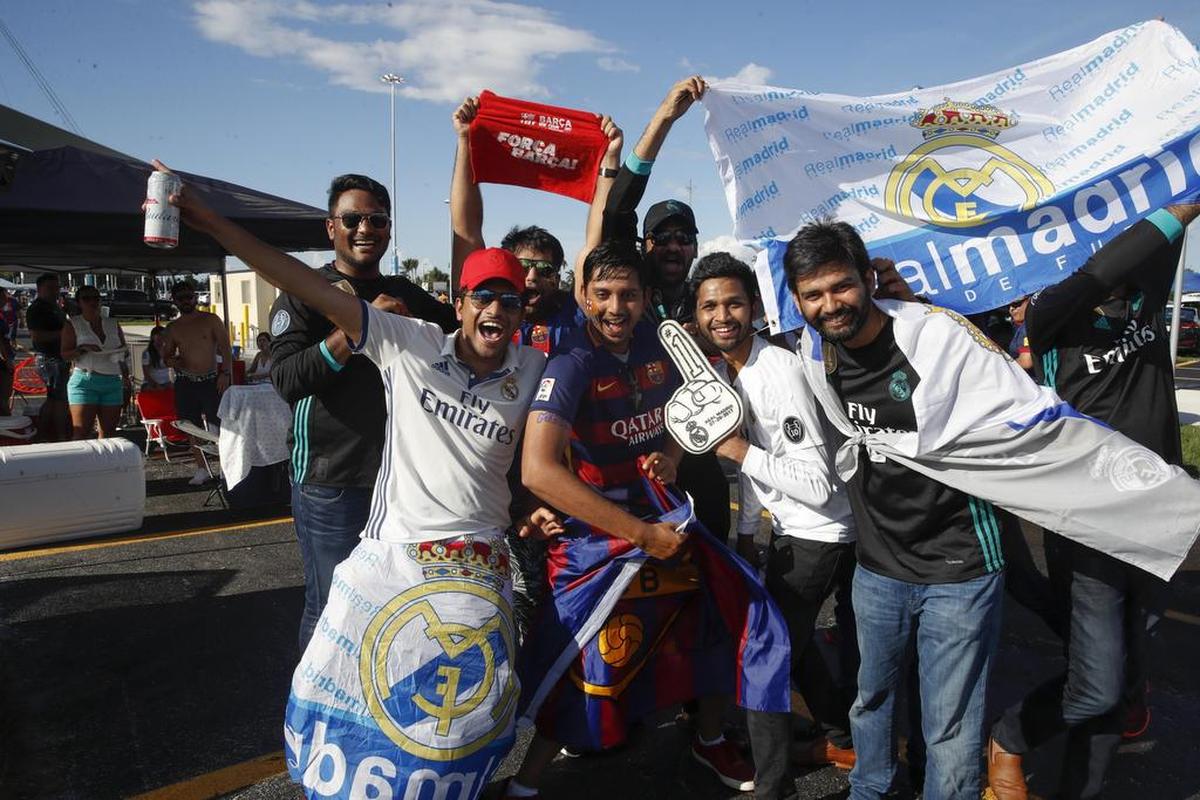 Aficionados del FC Barcelona y del Real Madrid posan con las camisetas de los equipos el sábado 29 de julio de 2017, antes del partido que enfrentará al Real Madrid contra el FC Barcelona, en el Estadio Hard Rock, en Miami.