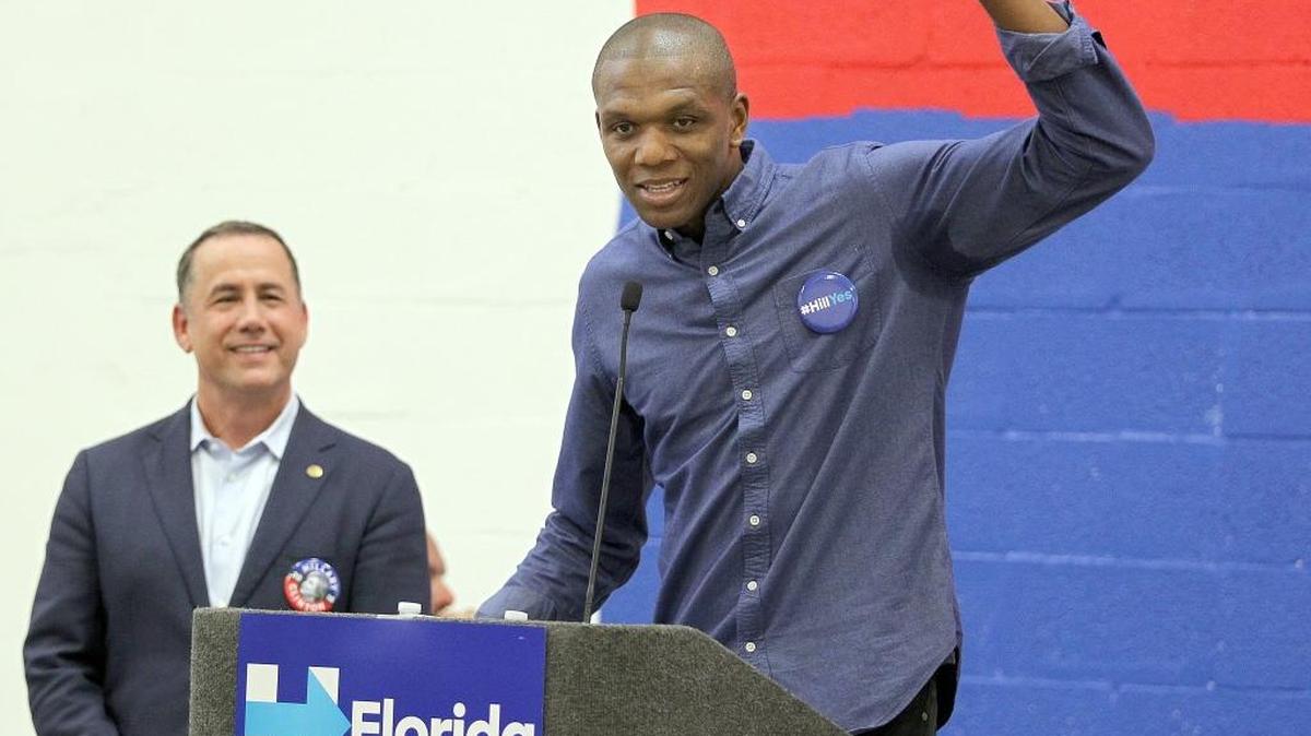 El alcalde de Miami Beach Phillip Levine, escucha al jugador de la NBA, James Jones de los Cleveland Cavaliers (anteriormente Miami Heat), hablar con partidiarios de Hillary Clinton, durante la apertura de la primera oficina de su campaña presidencial en Wynwood, Miami, el sábado 9 de julio del 2016.