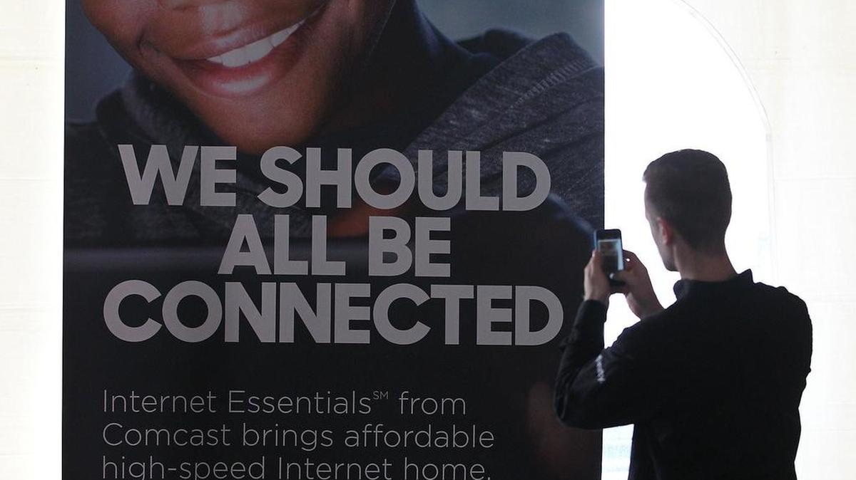Allen Levin, especialista de Comcast, frente a una pancarta publicitaria del programa piloto.