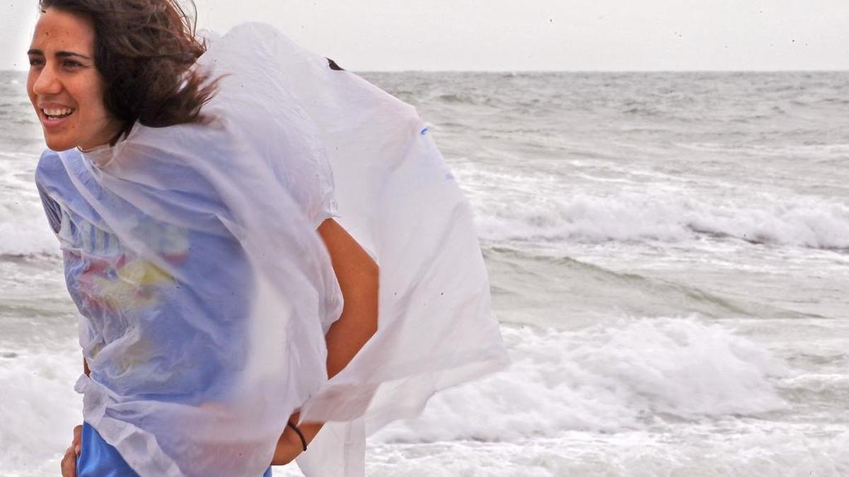 Katie Cusick, de 29 años, profesora local, hace un recorrido con miembros de la familia en la playa durante la aproximación de los fuertes vientos.