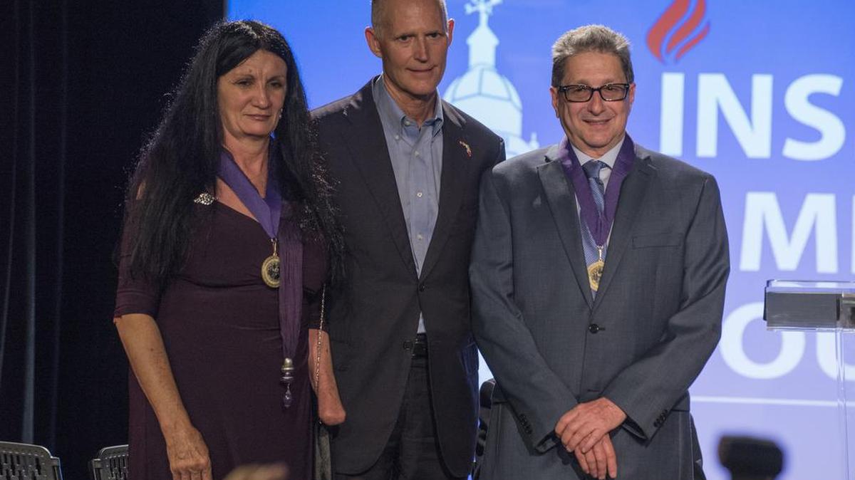 El gobernador de la Florida, Rick Scott (c), posa con el periodista cubano Pedro Corzo (d) y la integrante del partido Republicano de Cuba Siney Avila (i), luego de entregarles la medalla de la libertad el viernes 19 de mayo de 2017, en la ceremonia realizada con motivo del Día de la Independencia de Cuba que se recuerda cada 20 de mayo, en el Museo de la Diáspora Cubana en Coral Gables, Miami.