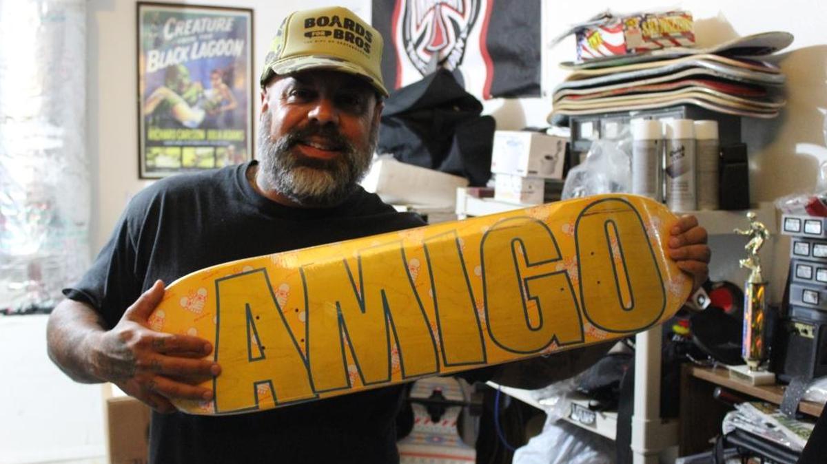 Rene Lecour con una tabla donde resalta la palabra “Amigo”, parte del nombre de su organización benéfica “Amigo Skate Cuba.”