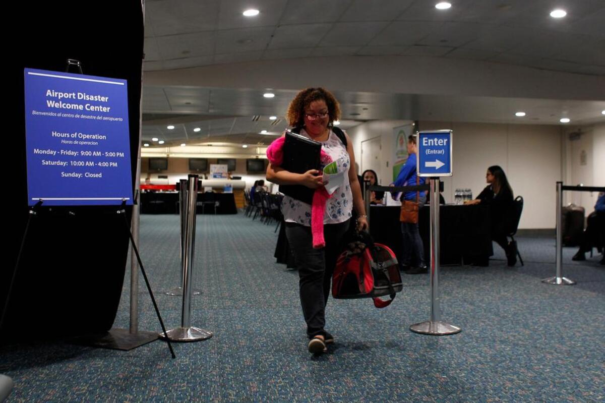 Cristina Sánchez, de 43 años, sale del Centro de Recepción para refugiados puertorriqueños establecido en el Aeropuerto Internacional de Orlando tras obtener información sobre asistencia en Orlando, Florida, el 30 de noviembre del 2017.