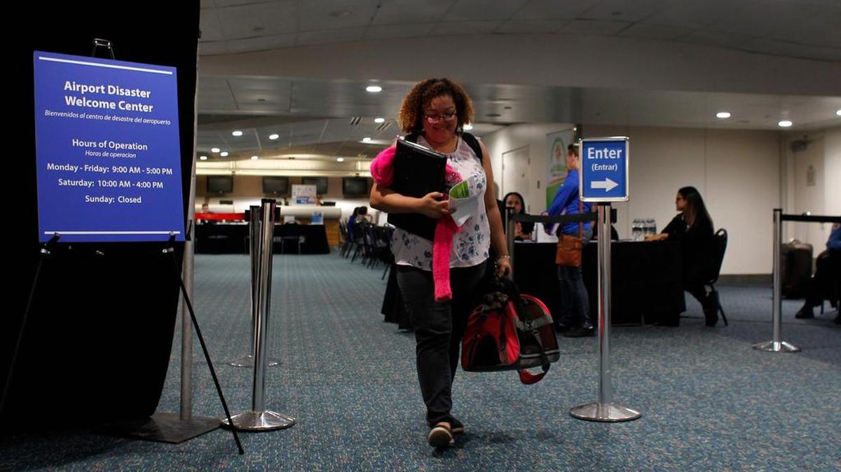 Cristina Sánchez, de 43 años, sale del Centro de Recepción para refugiados puertorriqueños establecido en el Aeropuerto Internacional de Orlando tras obtener información sobre asistencia en Orlando, Florida, el 30 de noviembre del 2017.