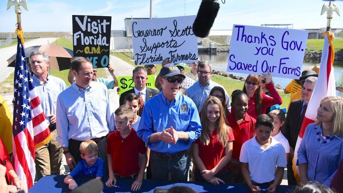 El gobernador de Florida, Rick Scott (cen.) habla el viernes sobre la ley que ordena la construcción de un gran embalse al sur del lago Okeechobee y evitar así el vertido de algas tóxicas y químicos en los estuarios de la costa y proteger los Everglades.