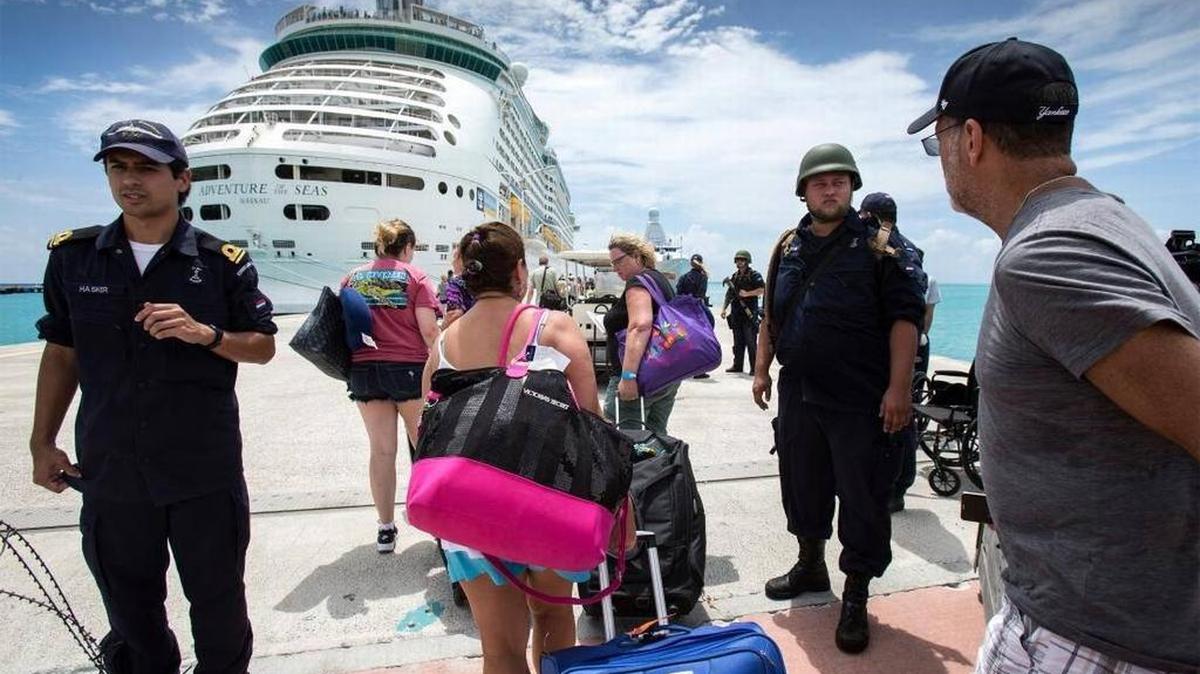 Esta imagen del 10 de septiembre cedida por el Ministerio de Defensa de Holanda muestra a personas que se dirigen a un barco de crucero anclado en San Martín, después del paso del huracán Irma.