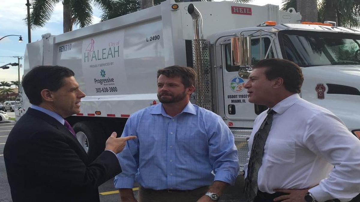 El abogado de Progressive Waste Solutions, Grant Smith, el subgerente en el sur de la Florida de esa compañía, John Heinemann, y el alcalde de Hialeah, Carlos Hernández, frente a uno de los camiones que a partir del lunes ofrecerá el servicio de recogida de basura en esa ciudad.
