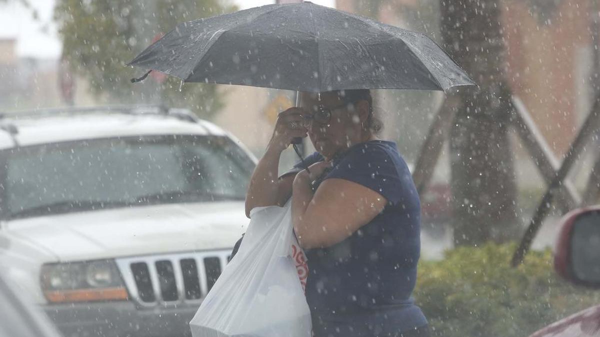 Una mujer se protege de la lluvia en Miami, en esta imagen del 28 de junio.
