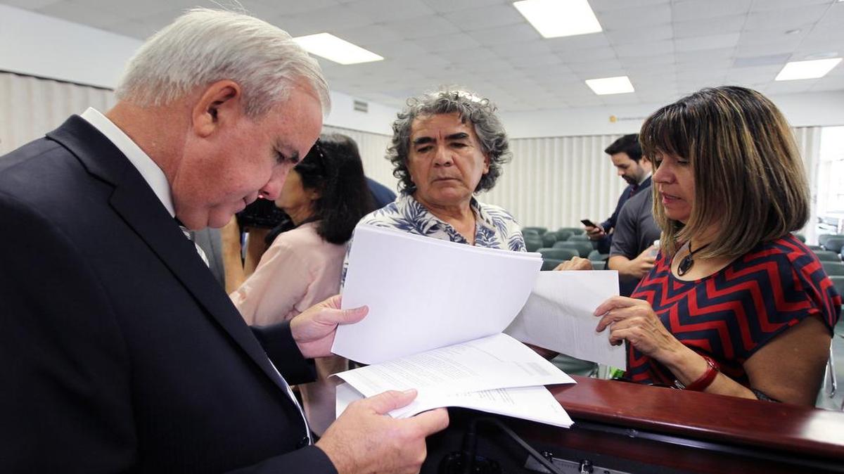 Carlos Giménez, alcalde del Condado de Miami-Dade, habla con Luz Moscoso y Rubén Gallardo, propietarios de condominios que asistieron a la sede de Policia de Miami Dade.