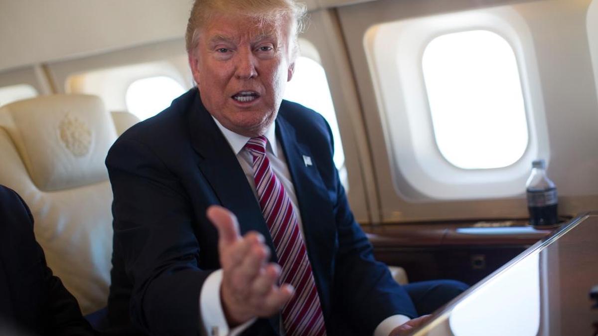 Republican presidential candidate Donald Trump talks with members of the media Monday aboard his campaign plane, while flying over Ohio.