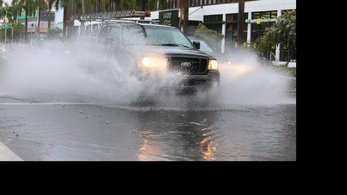 Un coche pasa por una calle inundada por las fuertes lluvias en Biscayne Blvd. el Miércoles, 15 de julio 2015 en Miami.