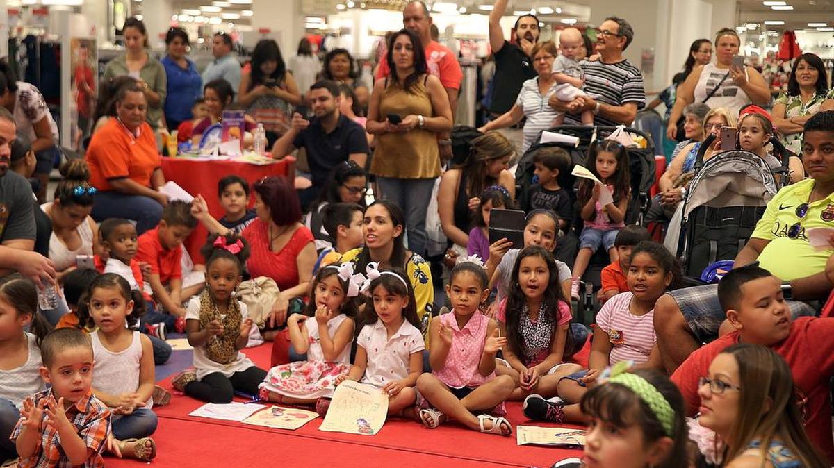 Los niños y sus familiares entonan canciones navideñas mientras esperan la llegada de los Reyes Magos en una celebración de Macy’s y Mundo Lanugo's Hispanic Heritage en Hialeah este sábado.