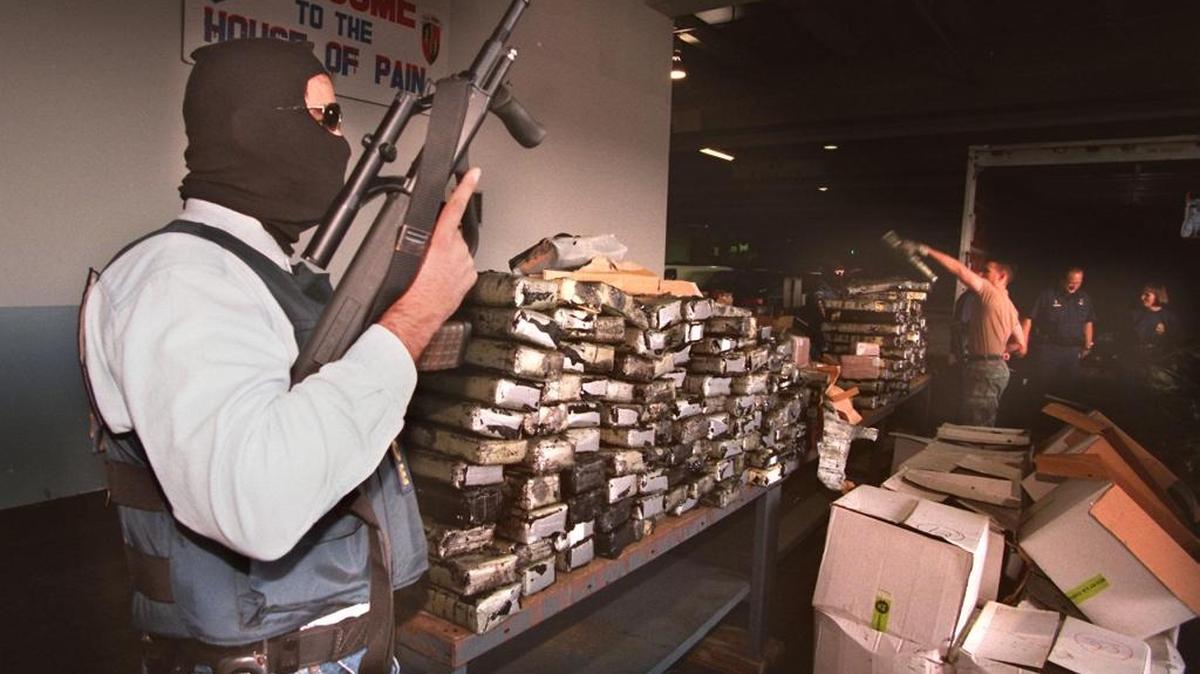 Agente de la DEA encapuchado resguarda un cargamento de cocaína interceptado por agentes aduanales dentro de un envío de asfalto procedente de Venezuela.