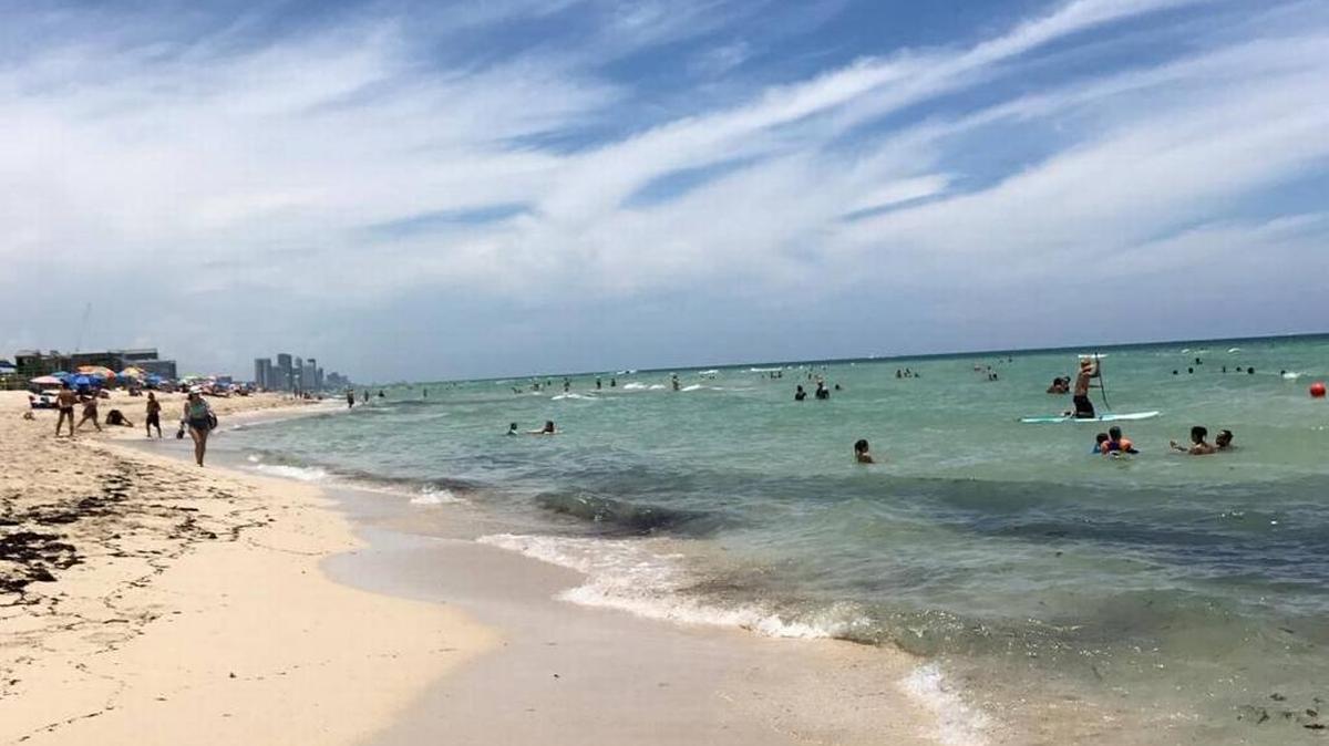 Personas acuden a disfrutar de un día de playa en Miami.