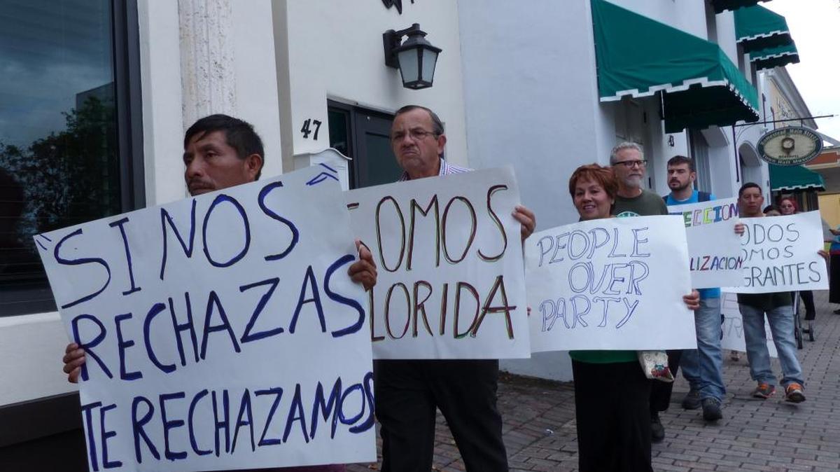Victoriano AguIIar (izda) y Levis Torres (dcha) junto a los miembros de varios grupos por los derechos de los indocumentados se manifestaron este jueves frente a las oficinas de la representante de Florida Holly Merrill Raschein (R), quien votó a favor del proyecto de ley HB 675 que castiga a las llamadas ciudades "santuario" por limitar su cooperación con las autoridades federales migratorias.
