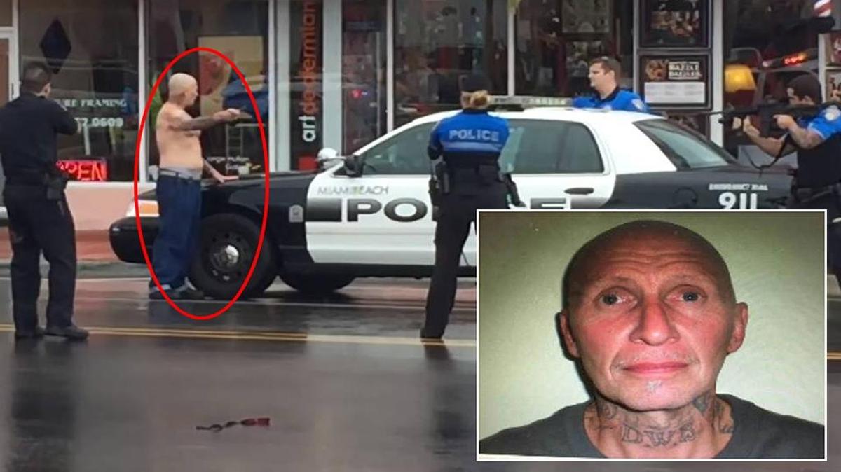David Winesett (i, marcado por un círculo rojo) sostiene una navaja frente a varios oficiales de la policía de Miami Beach.