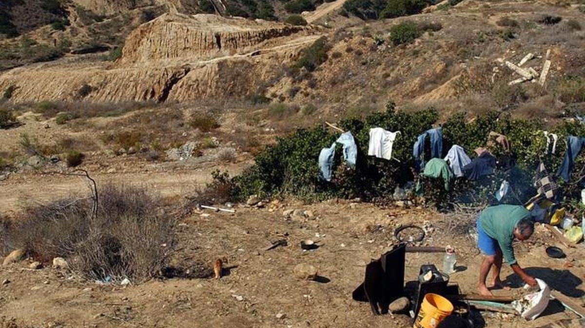 Tres hombres esperan la noche para poder cruzar ilegalmente a Estados Unidos cerca de Tijuana, Baja California, México.