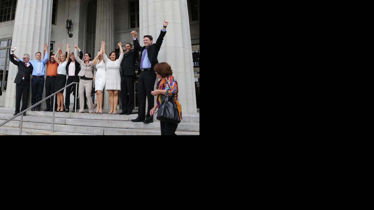 
Varias parejas que demandaron al Condado Miami-Dade para exigir la legalización del matrimonio gay posan el lunes, 5 de enero del 2015, en las escaleras del tribunal en downtown Miami tras la histórica decisión. 
