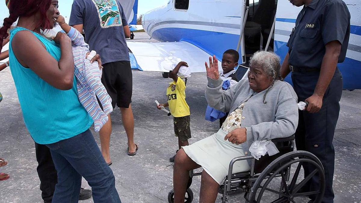 
Un oficial de la policía de Bahamas ayuda a evacuar a la anciana Elizabeth Ferguson desde Crooked Island, el sábado 10 de octubre.


