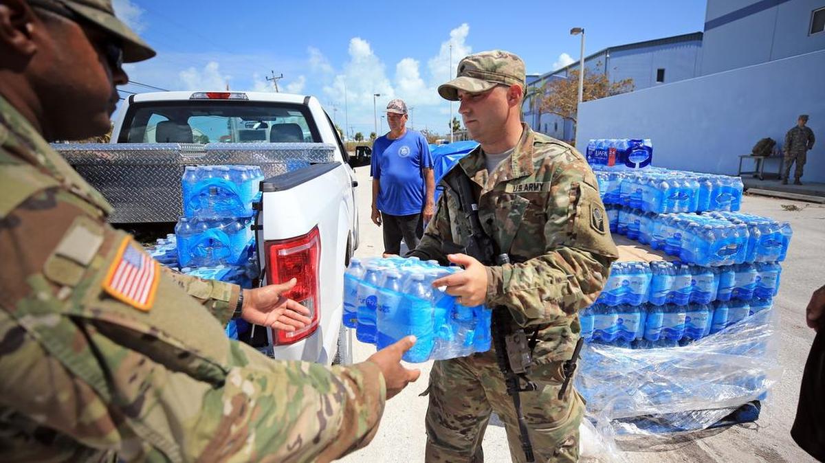 Soldados de la Guardia Nacional de la Florida cargan agua embotellada para los residentes en la escuela secundaria Marathon el miércoles, 13 de septiembre de 2017.
