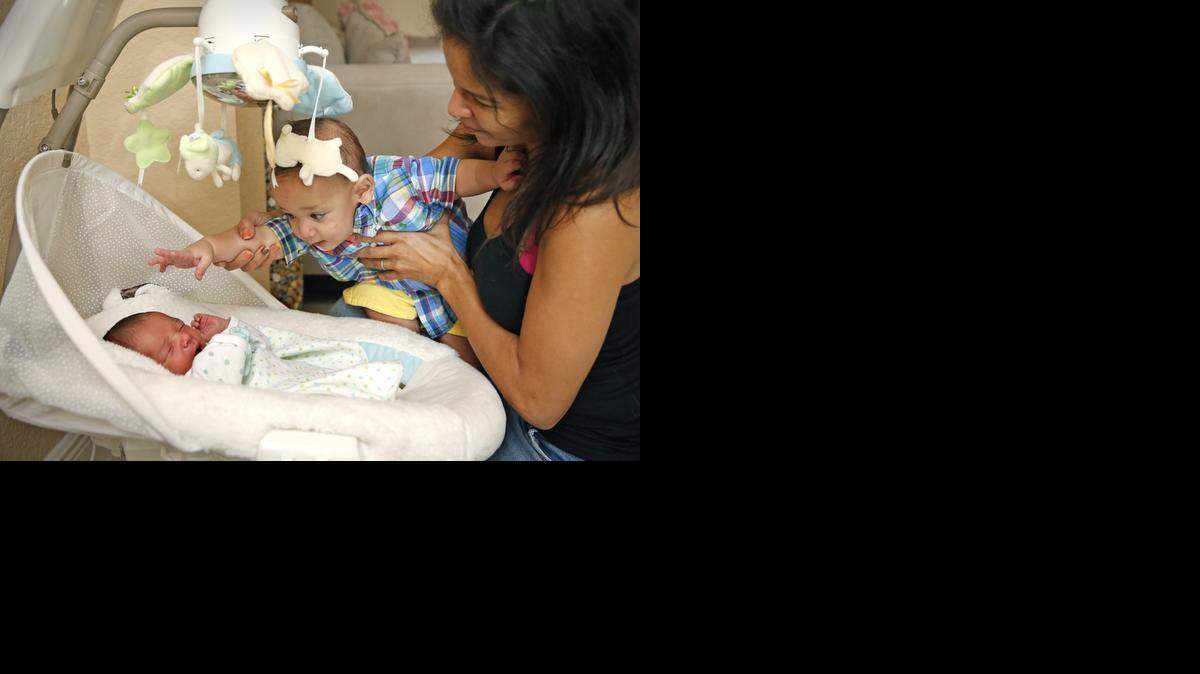 
Pamela Rauseo sostiene a su sobrino Sebastián de la Cruz mientras este se entretiene con su hermanita recién nacida Chloe. Rauseo le salvó la vida a Sebastián cuando le practicó reanimación cardio-pulmonar (RCP) en la Autopista 836 el 26 de febrero.
