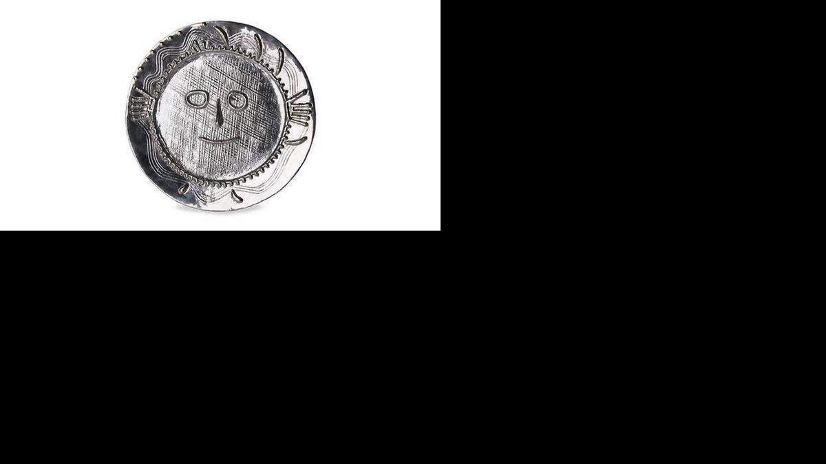 
Este plato en plata es conocido como el Visage aux Mains (Cara con manos), 1956, de Pablo Picasso
