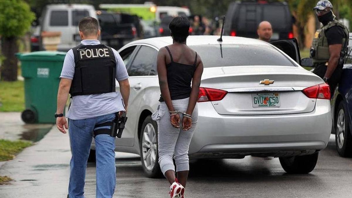 Un agente de la Policía de Miami-Dade lleva arrestada a una mujer que estaba dentro de la vivienda del sospechoso de tráfico de carfentanil.