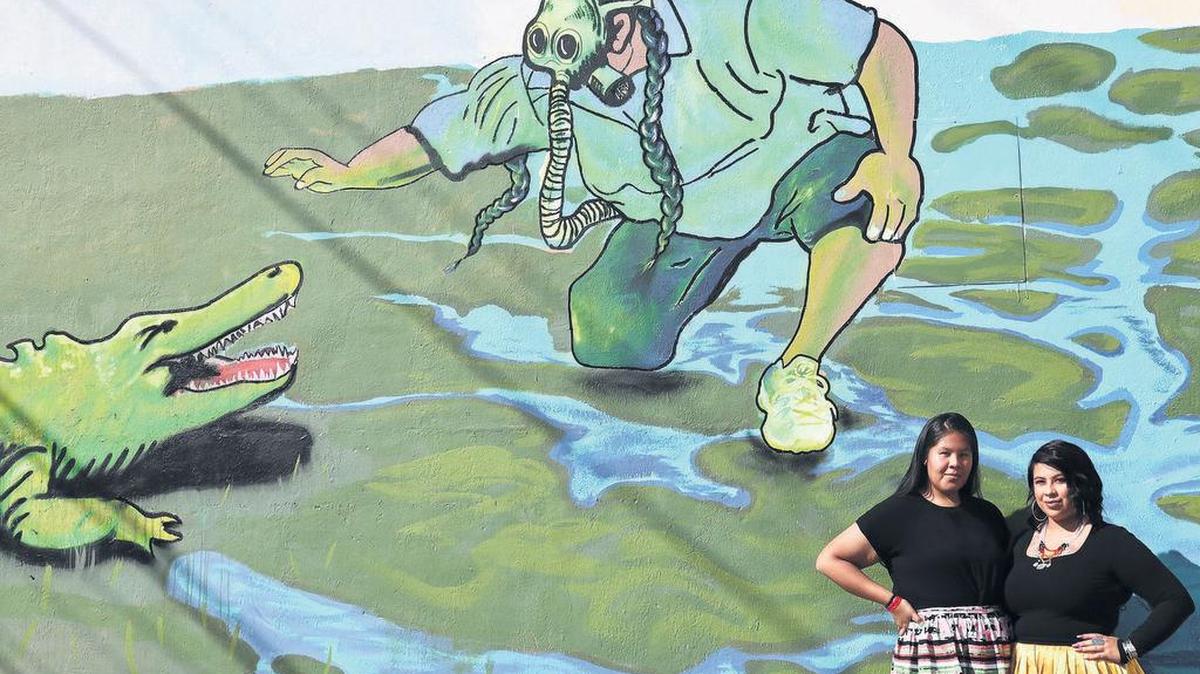 Las hermanas Katrina, izquierda, y Angel Bowers posan junto a un mural de Bunky Eco-Hawk develado el jueves por la mañana en Wynwood .