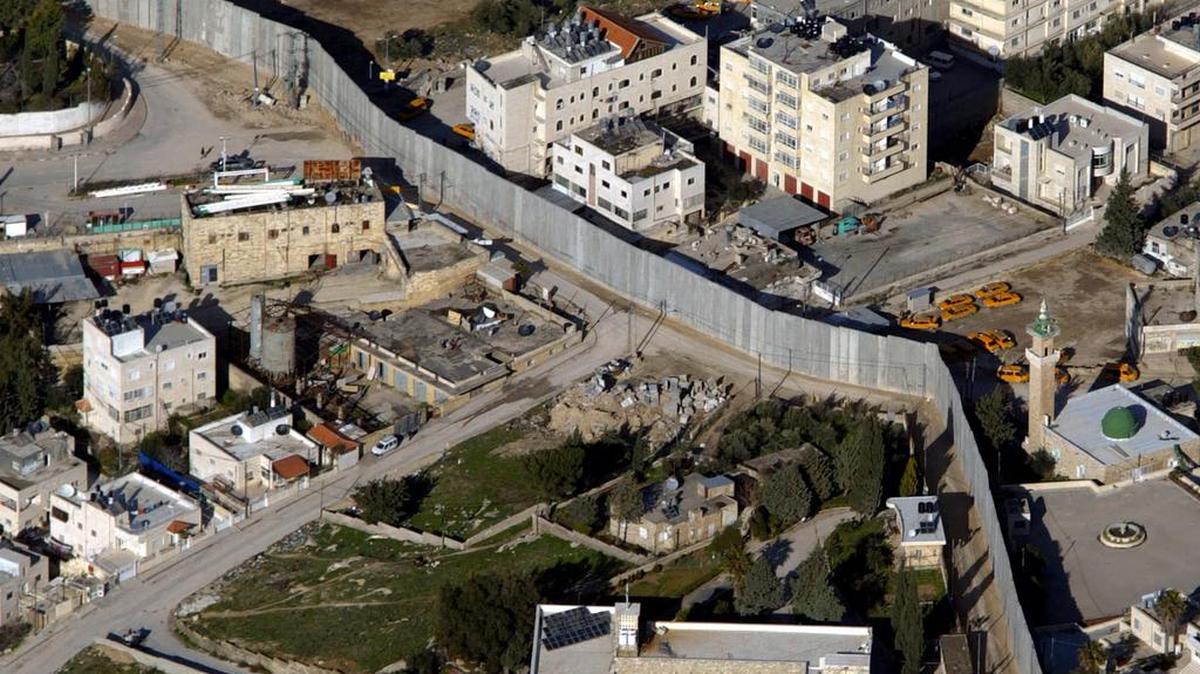 Vista aérea del muro de ocho metros que separa suburbios árabes e israelíes en Jerusalén.