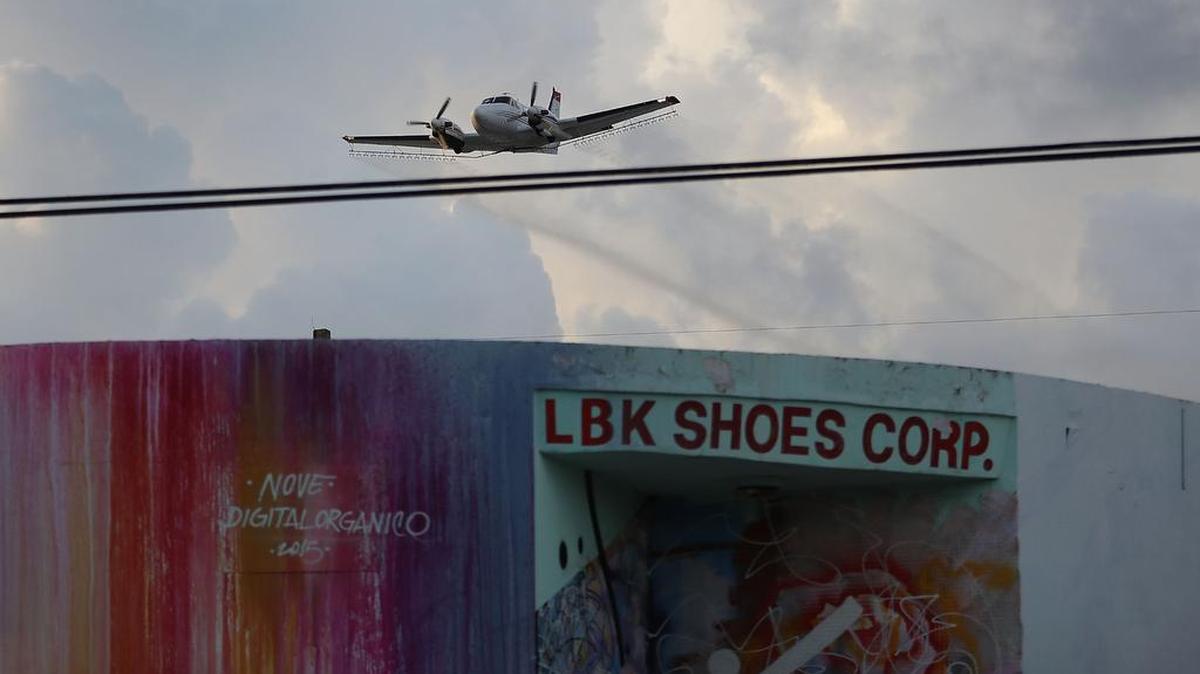 Un avión esparce pesticida sobre el barrio de Wynwood con la esperanza de controlar y reducir el número de mosquitos, algunos de los cuales son capaces de propagar el virus Zika el 6 de agosto, 2016, en Miami, Florida.