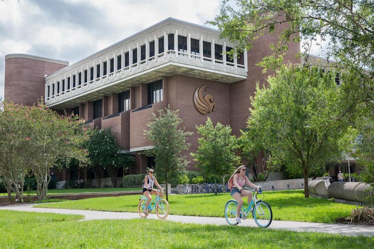 Dos estudiantes pasean en bicicleta en el campus de la Universidad Central de Florida (UCF).