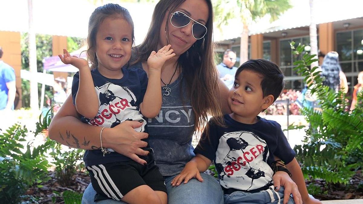 Marilú Saquieres posa con sus mellizos Luka (izq.) y Bruno, durante una ceremonia para familias organizada por el sistema de Escuelas Públicas del Condado Miami-Dade en el parque de diversiones Jungle Island en Miami, en abril pasado.