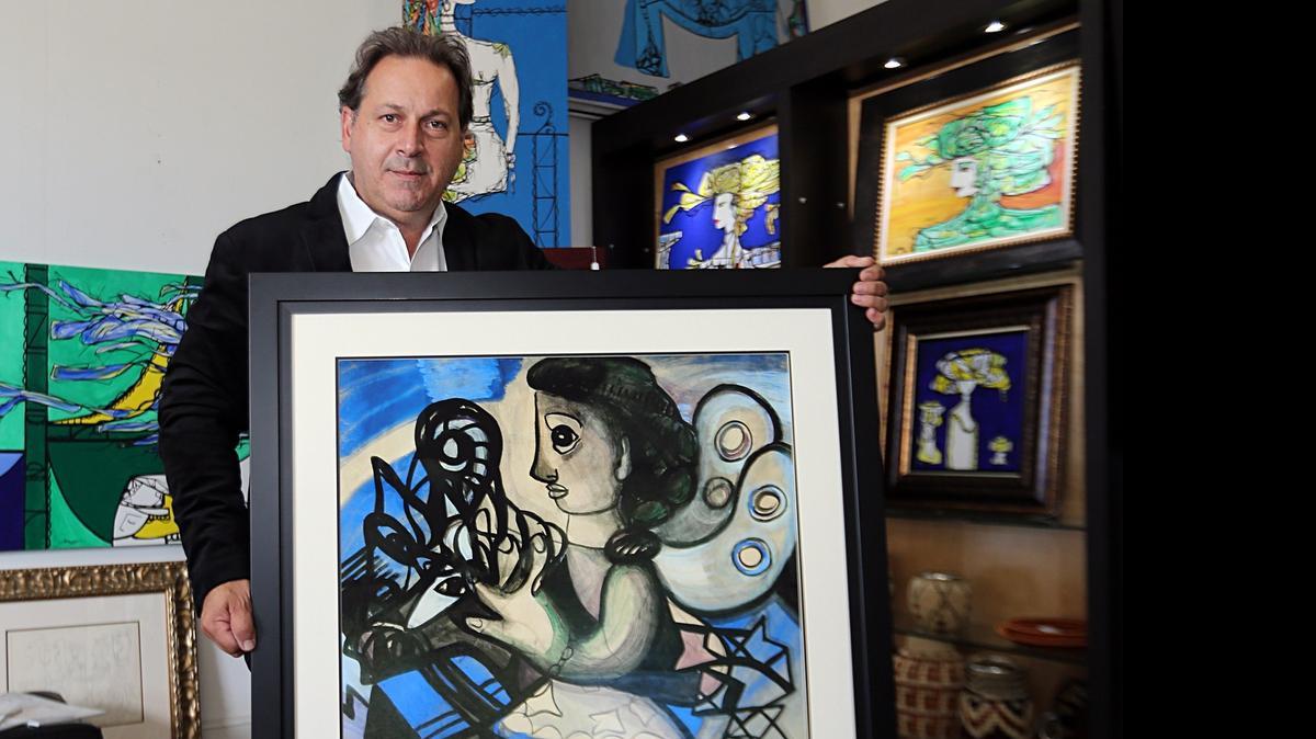 
El pintor Emilio Sauma, fundador y presidente del Coral Gables Hispanic Cultural Foundation, muestra el cuadro ‘Angel azul’, de Amelia Peláez, a cuya obra se dedica el Coral Gables Hispanic Cultural Festival este año, que se celebra el 24 y 25 de octubre.

