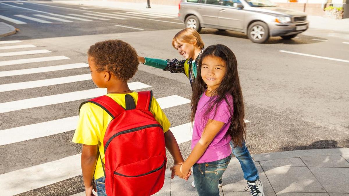 Foto de archivo que muestra a tres niños tomados de la mano, a punto de cruzar la calle. En el 2014, 34 niños y niñas peatones fallecieron en la Florida, una cifra que fue solo superada por California, con 41 muertes.