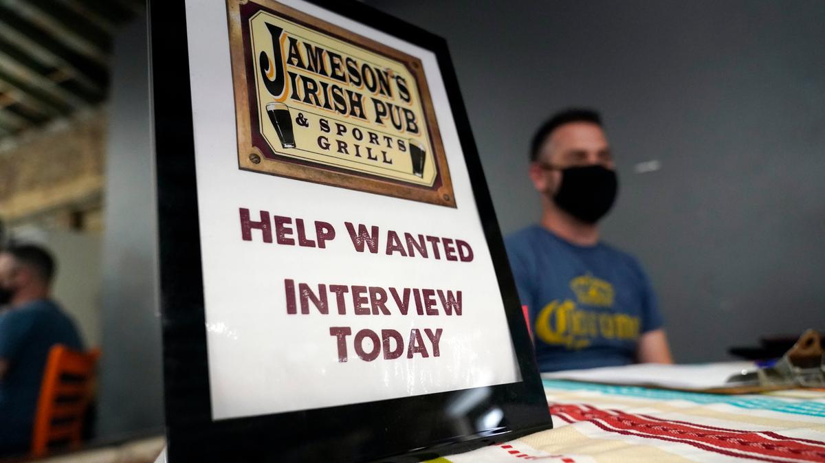 FILE - A hiring sign is shown at a booth for Jameson’s Irish Pub during a job fair on Sept. 22, 2021, in the West Hollywood section of Los Angeles. Hiring in California slowed significantly in November 2021 even as the state’s unemployment rate dipped below 7% for the first time since March 2020, at the start of the pandemic, according to data made public Friday, Dec. 17, 2021. (AP Photo/Marcio Jose Sanchez, File)