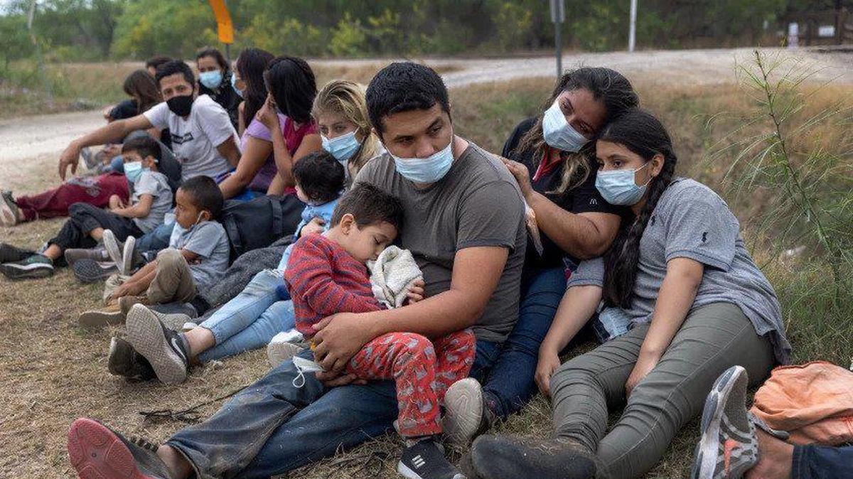 Una familia guatemalteca espera con otros inmigrantes para abordar un autobús hacia un centro de procesamiento después de cruzar la frontera con México en Texas.