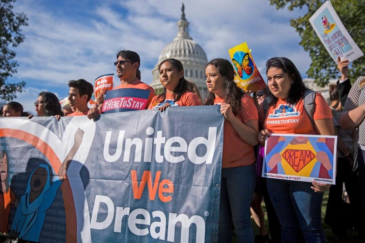Manifestantes sostienen pancartas y gritan consignas durante una rueda de prensa de la legisladora Elizabeth Warren con defensores del programa DACA, en Washington el 5 de octubre.