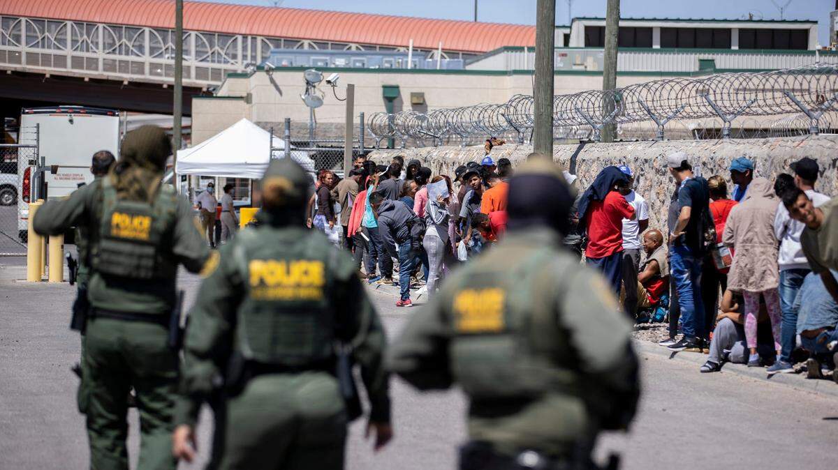 Un grupo de migrantes espera para entregarse a la Oficina de Aduanas y Protección Fronteriza de EE. UU. en la subestación del puente Paso del Norte, en El Paso, Texas, el martes 9 de mayo de 2023. 