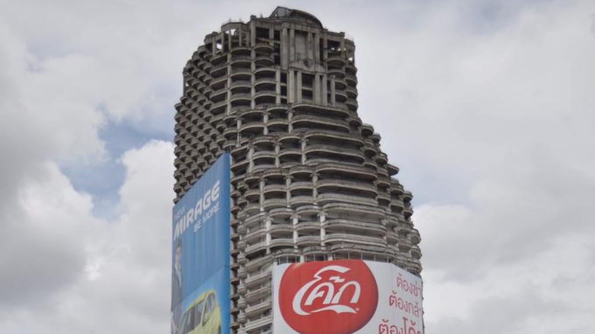 
Vista general del edificio Sathorn Unique, a las orillas del río Chao Phraya en Bangkok, abandonado hace casi dos décadas. El techo abovedado del Sathorn Unique, un imponente rascacielos inacabado, muestra su esqueleto de ferralla oxidada y para algunos también embrujada después de que la obra fuera paralizada hace casi veinte años en Bangkok.
