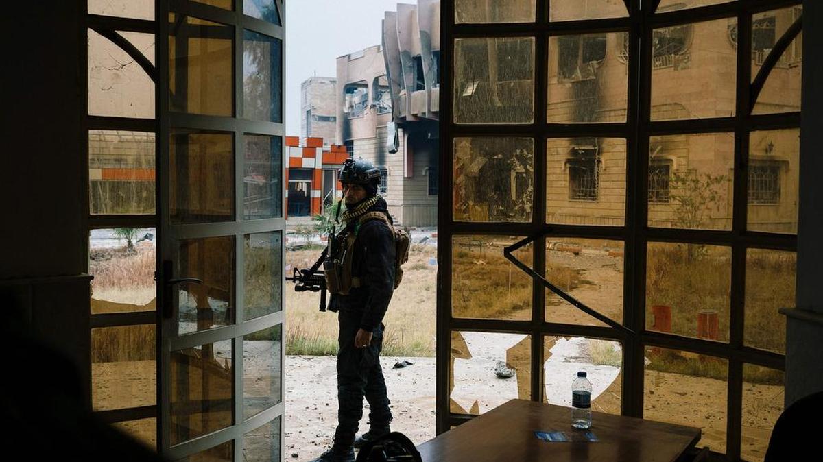 Un miembro de las fuerzas especiales de Irak vigilan la entrada a un edificio dañado de la Universidad de Mosul, el lunes.