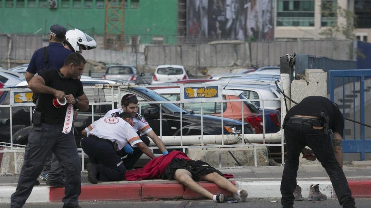 Miembros de  los servicios de rescate cubren el cuerpo de una víctima palestina en Tel Aviv, Israel, el jueves.