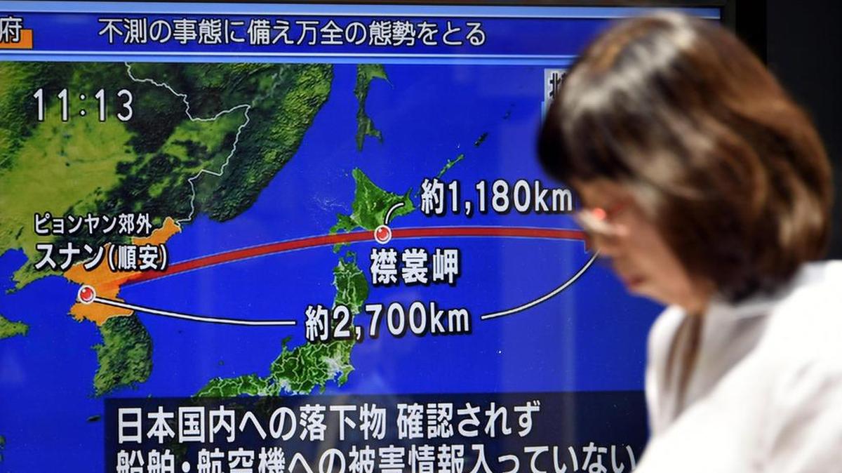 Un peatón pasea frente a una pantalla de televisión en una calle que transmite la última hora del lanzamiento de un misil por parte de Corea del Norte el martes 29 de agosto de 2017, en Tokio (Japón).