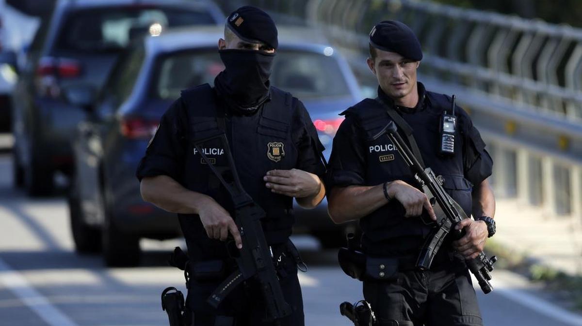 Dos polícias vigilan una carretera cerca de Subirast, un pueblo al oeste de Barcelona, España, en donde se llevó acabo un operativo policial el 21 de agosto de 2017, en búsqueda de posibles participantes del ataque terrorista en La Rambla.
