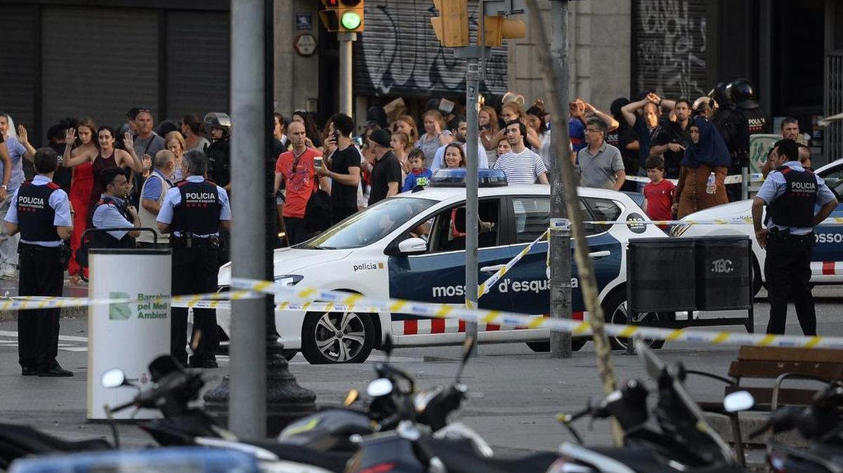 La gente deja con las manos arriba después de que una furgoneta arrolló a una multitud, matando a varias personas een la Rambla de Barcelona el 17 de agosto de 2017.