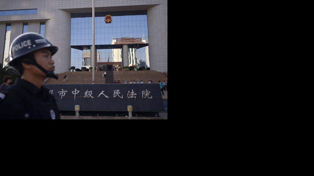 <cutline_leadin>Un policia</cutline_leadin> chino vigila fuera de la Corte del Pueblo en Kunming, suroeste de China. El viernes comenzó el juicio de cuatro personas acusadas de matar a cuchilladas a 31 personas en una estación de ferrocarril.